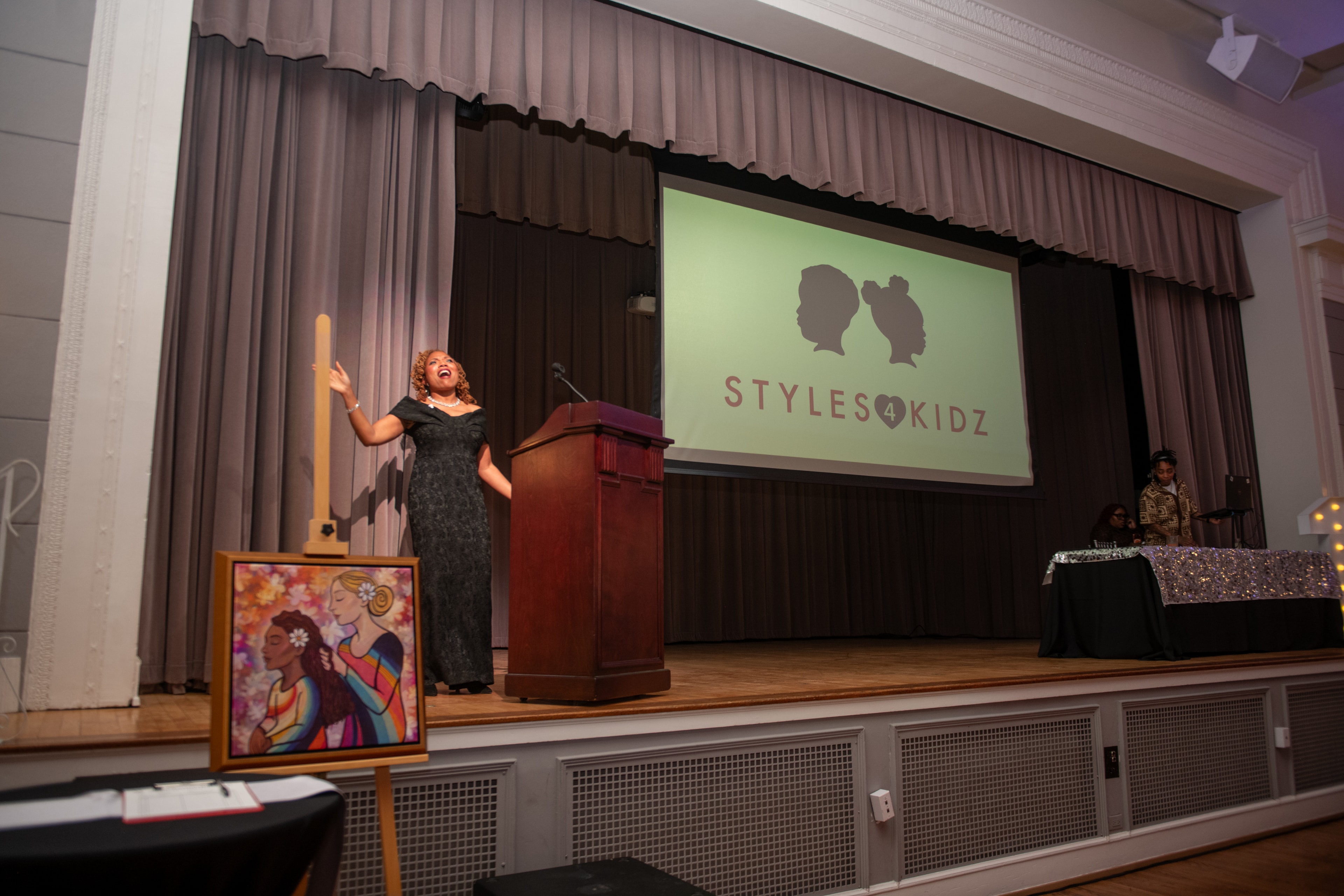 Tamekia Swint speaking on stage at a Styles 4 Kidz event